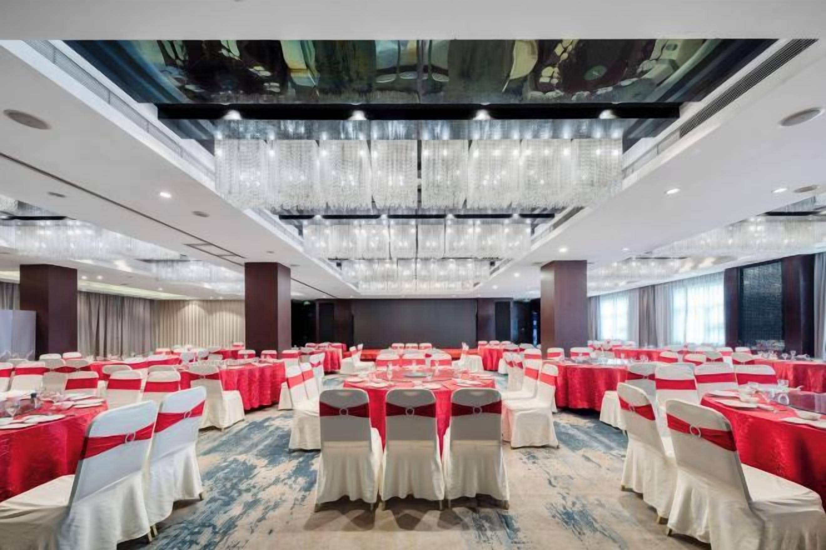 A banquet hall with rows of tables, chairs, and a chandelier.
