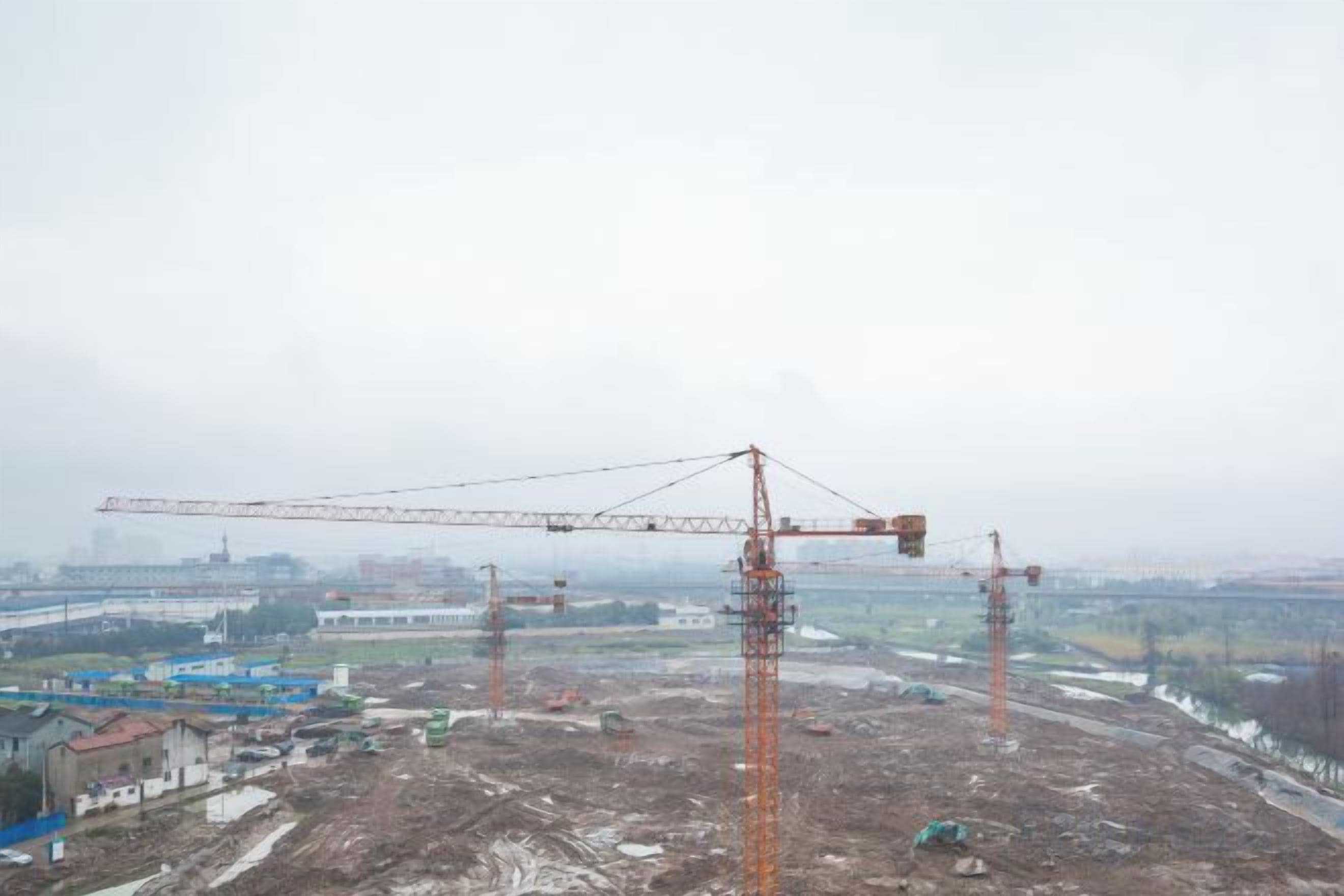 A construction site with multiple cranes and a large open area.