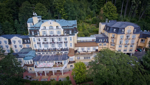 Un gran hotel con varias construcciones, balcones y un patio central.