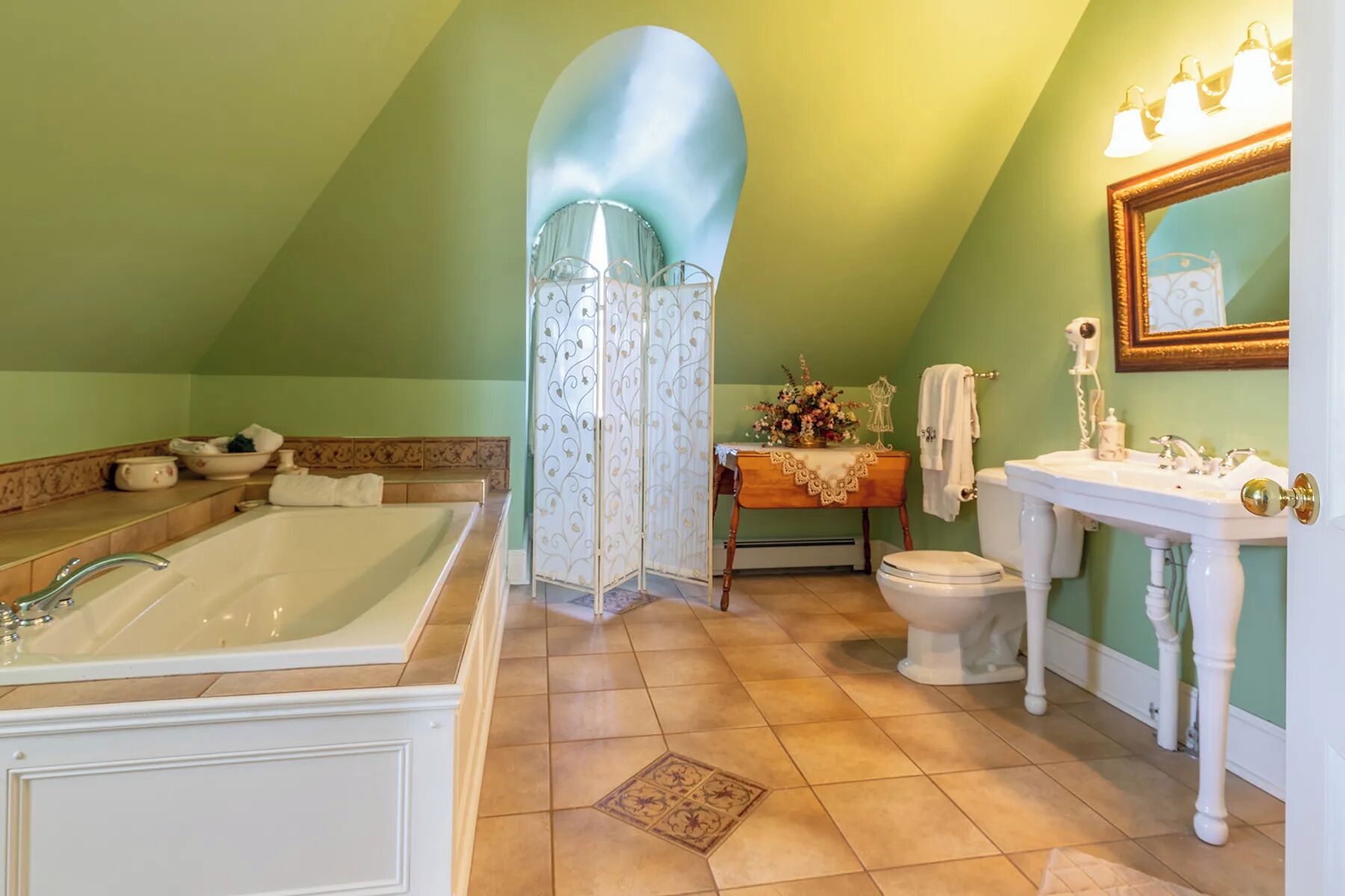 Un baño con una bañera grande, un inodoro y un lavabo.