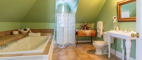 Un baño con una bañera grande, un inodoro y un lavabo.
