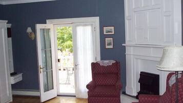 A room with a blue wall, a white fireplace, and a red armchair.