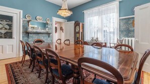 Una sala da pranzo con un tavolo in legno, sedie e un lampadario.
