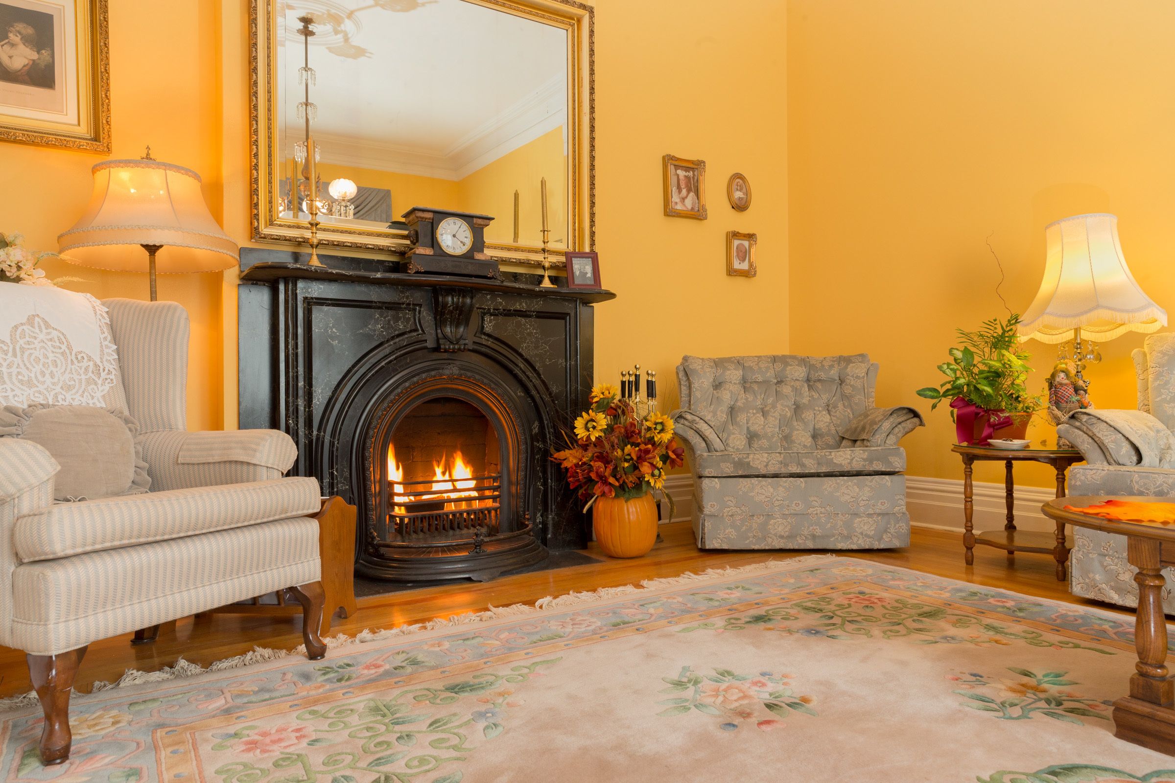 Una sala acogedora con chimenea, un tapete estampado y un sillón cómodo.