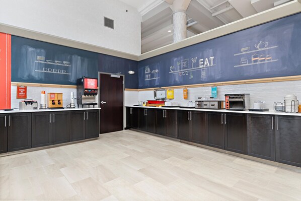 A modern kitchen with a chalkboard wall displaying food-related drawings and text, a coffee machine, and various kitchen appliances.