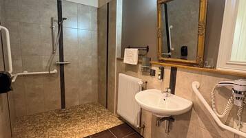 A modern bathroom with a shower, a sink, and a toilet.