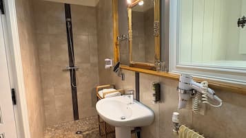 A bathroom with a shower, sink, and toilet.