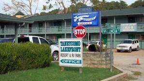 A sign for Taneycomo Lakefront Resort & RV Park office, a stop sign, and a building with a green roof. - Taneycomo Lakefront Resort (Branson)