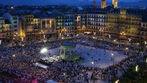 Una plaza con una fuente central y edificios circundantes, incluyendo una destacada torre con reloj.
