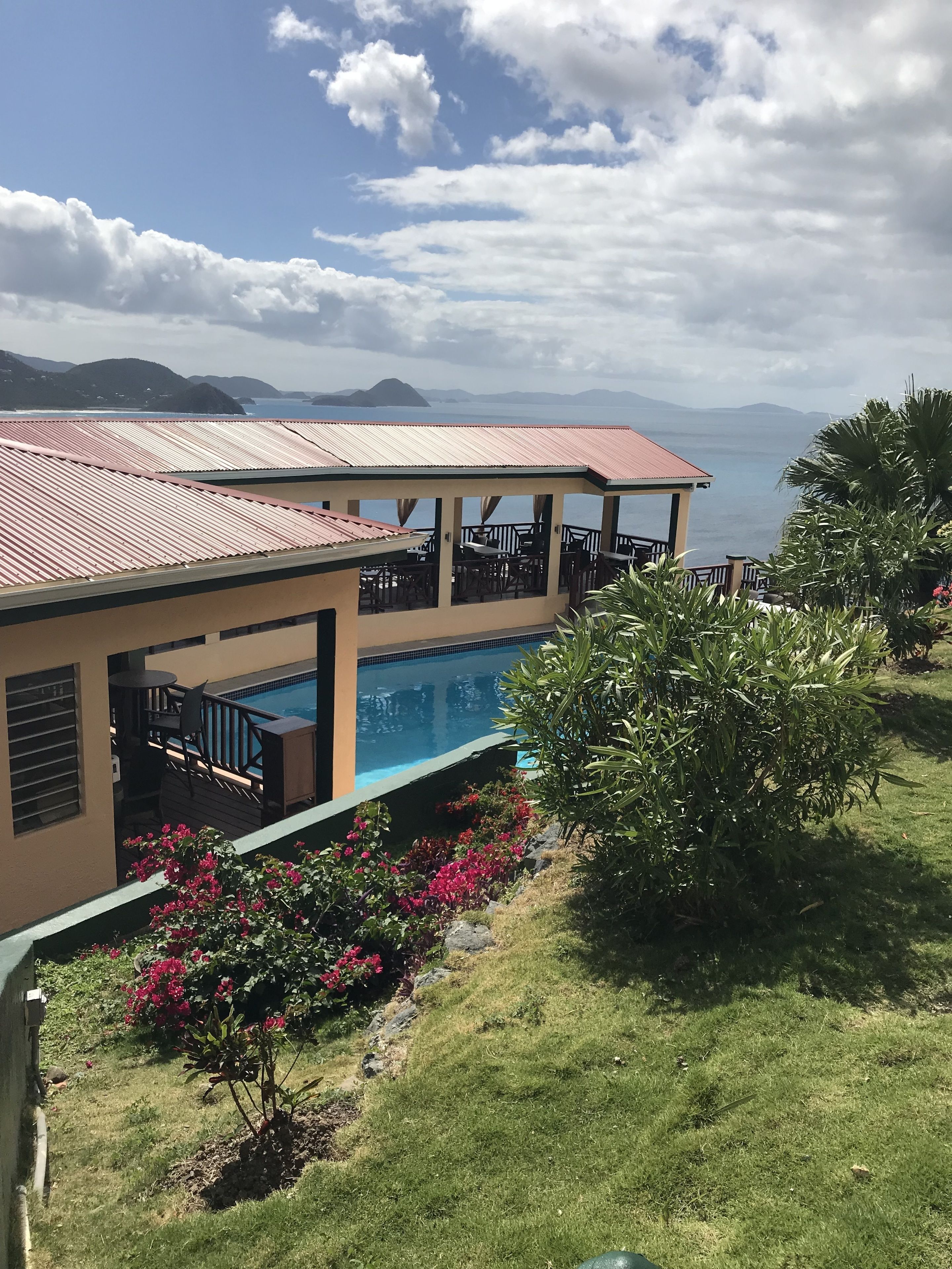 Ein Resort mit Pool, Außenbereich und Blick auf das Meer und die Berge.