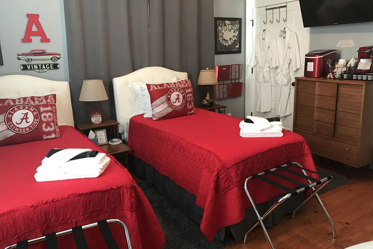 Habitación de hotel con dos camas, televisión, armario y escritorio con cafetera.