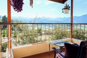 A balcony with a view of mountains, a table, and chairs. - Altocerro Villas Hotel & Camping (Constanza)