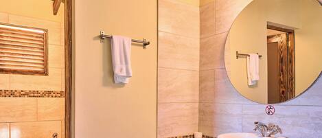 A bathroom with a sink, mirror, and towel rack.