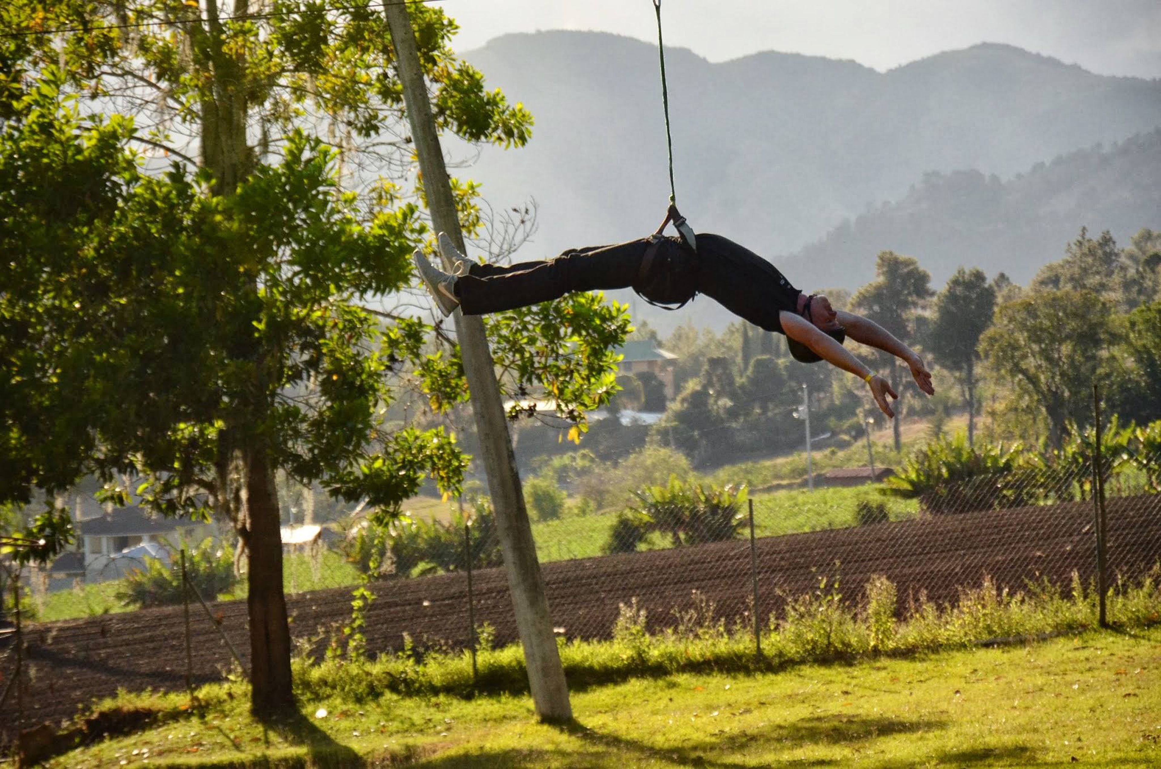 A person performing an aerial acrobatics routine on a trapeze.