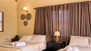 A hotel room with two beds, a telephone, a lamp, and a wall with decorative plates. - Altocerro Villas Hotel & Camping (Constanza)
