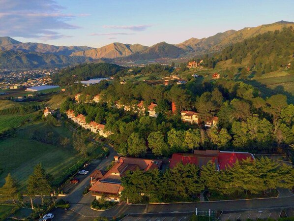 An aerial view of a residential area with houses, a road, and surrounding hills. - Altocerro Villas Hotel & Camping (Constanza)