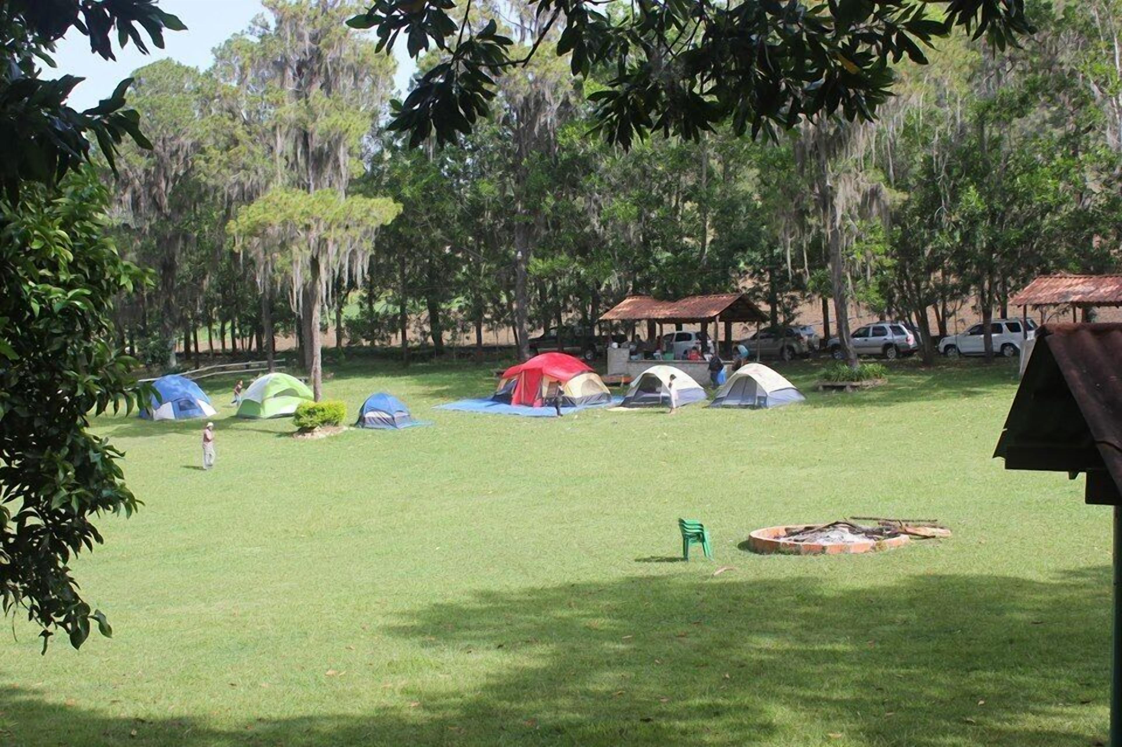 A campsite with multiple tents and a small fire pit.