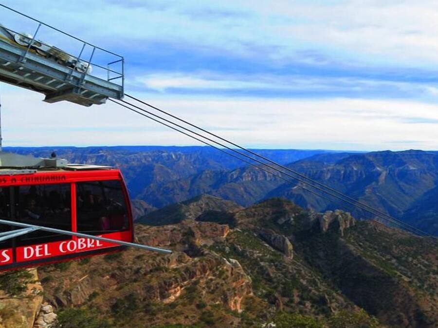A cable car with "Bierveredos a Chimborazo" and "Rancas del Cobre" signage, offering a view of the Andes mountains.