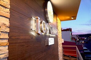 A hotel sign with the name 'Los Valdos' illuminated, a wooden facade, and a power outlet. - Hotel Los Valles (Bocoyna)