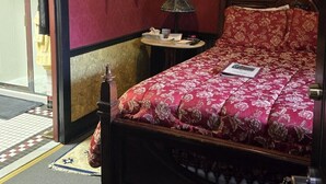 A bedroom with a bed, a nightstand, a lamp, a framed picture, and a wall-mounted animal head. - Historic Farnsworth House Inn (Gettysburg)