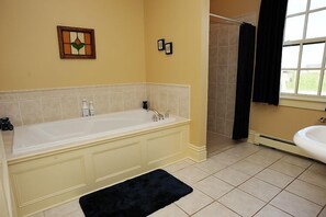 A bathroom with a bathtub, a shower, and a sink.