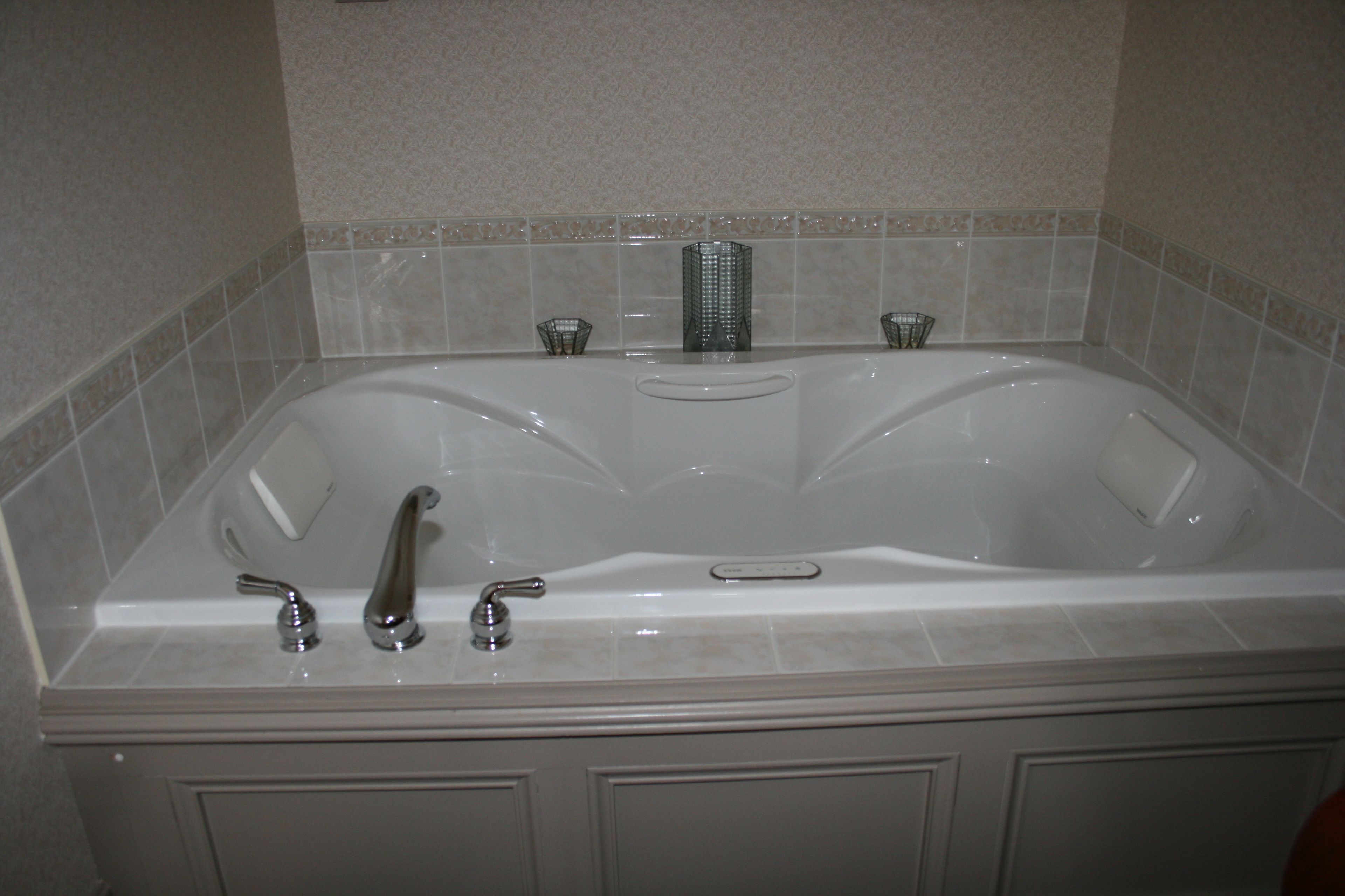 A large, rectangular bathtub with two faucets and a single drain.