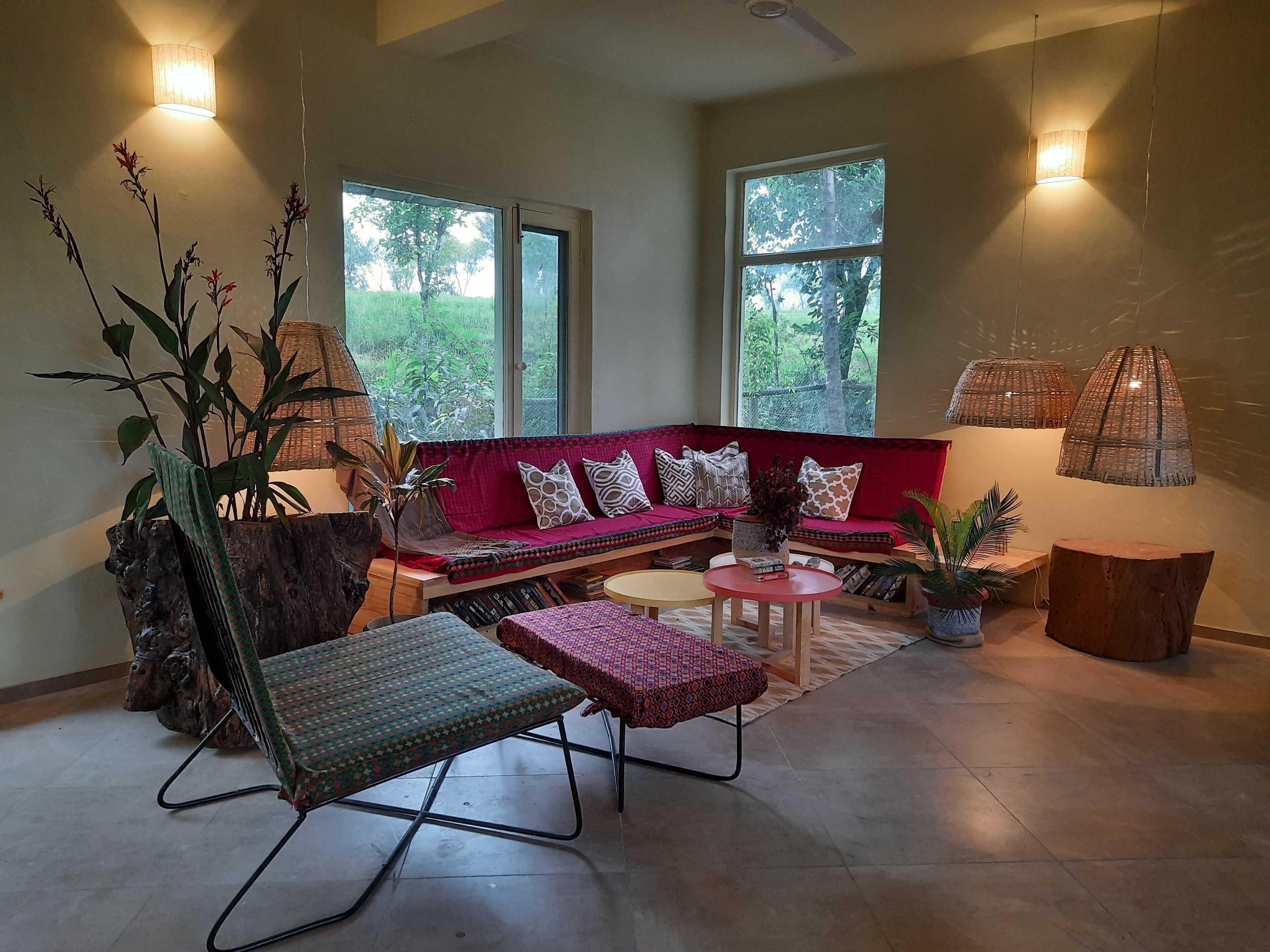 A cozy living room with a red sofa, a wooden coffee table, and a floor lamp.