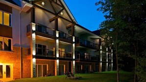 A multi-story hotel with a modern architectural design, featuring balconies and large windows. - Manoir du Lac William (St-Ferdinand)
