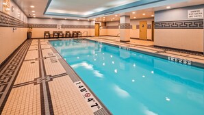 Una piscina interior con una zona poco profunda, indicadores de profundidad y un letrero que prohíbe los clavados.