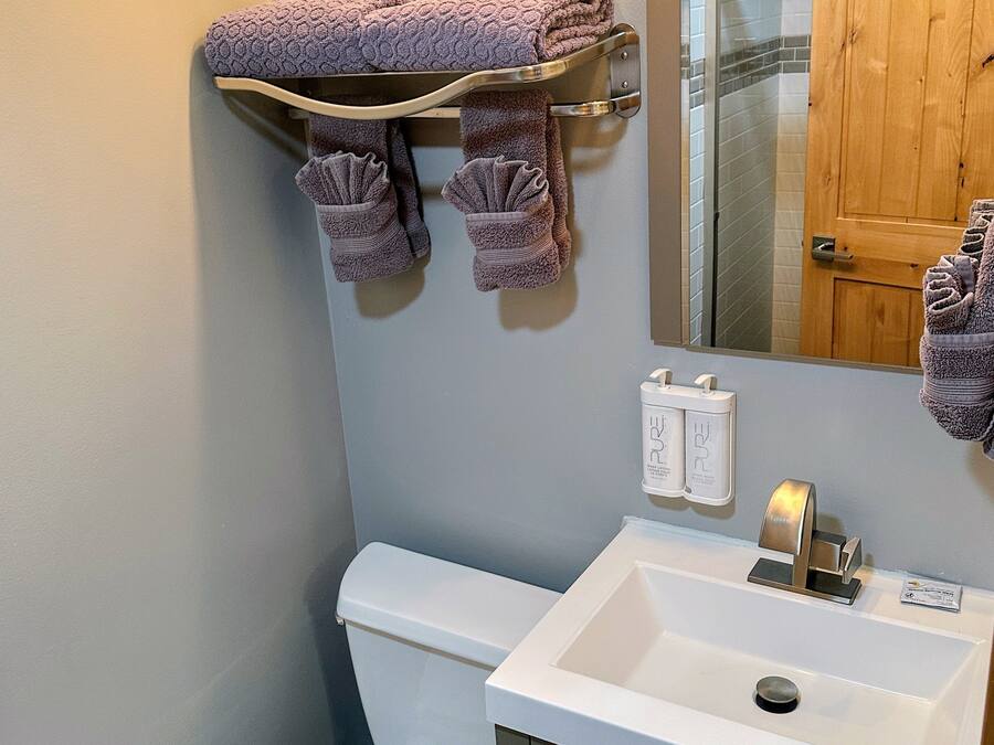 A bathroom with a toilet, sink, and towel rack.