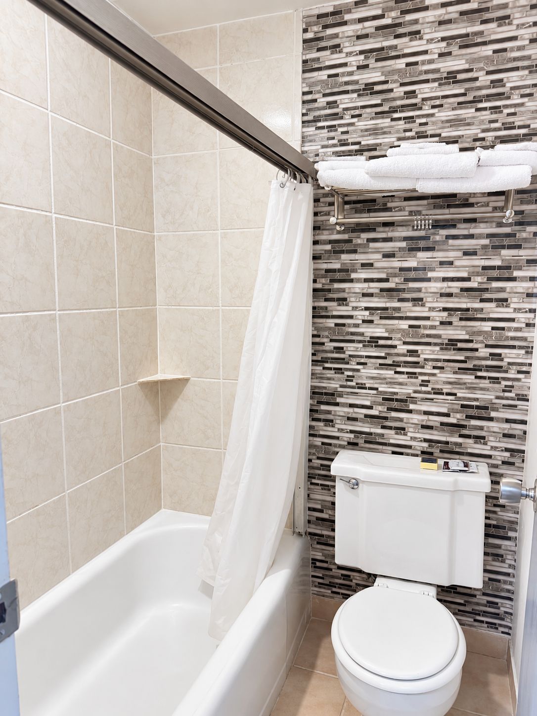 Un baño con bañera, inodoro y cortina de ducha.