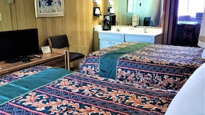 A hotel room with a bed, a desk with a television, a dresser, and a mirror. - Town House Motor Inn (Worland)