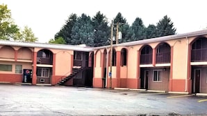 A building with multiple arched windows and a staircase leading to an upper level. There is a sign labeled "OFFICE" on the right side. - Town House Motor Inn (Worland)