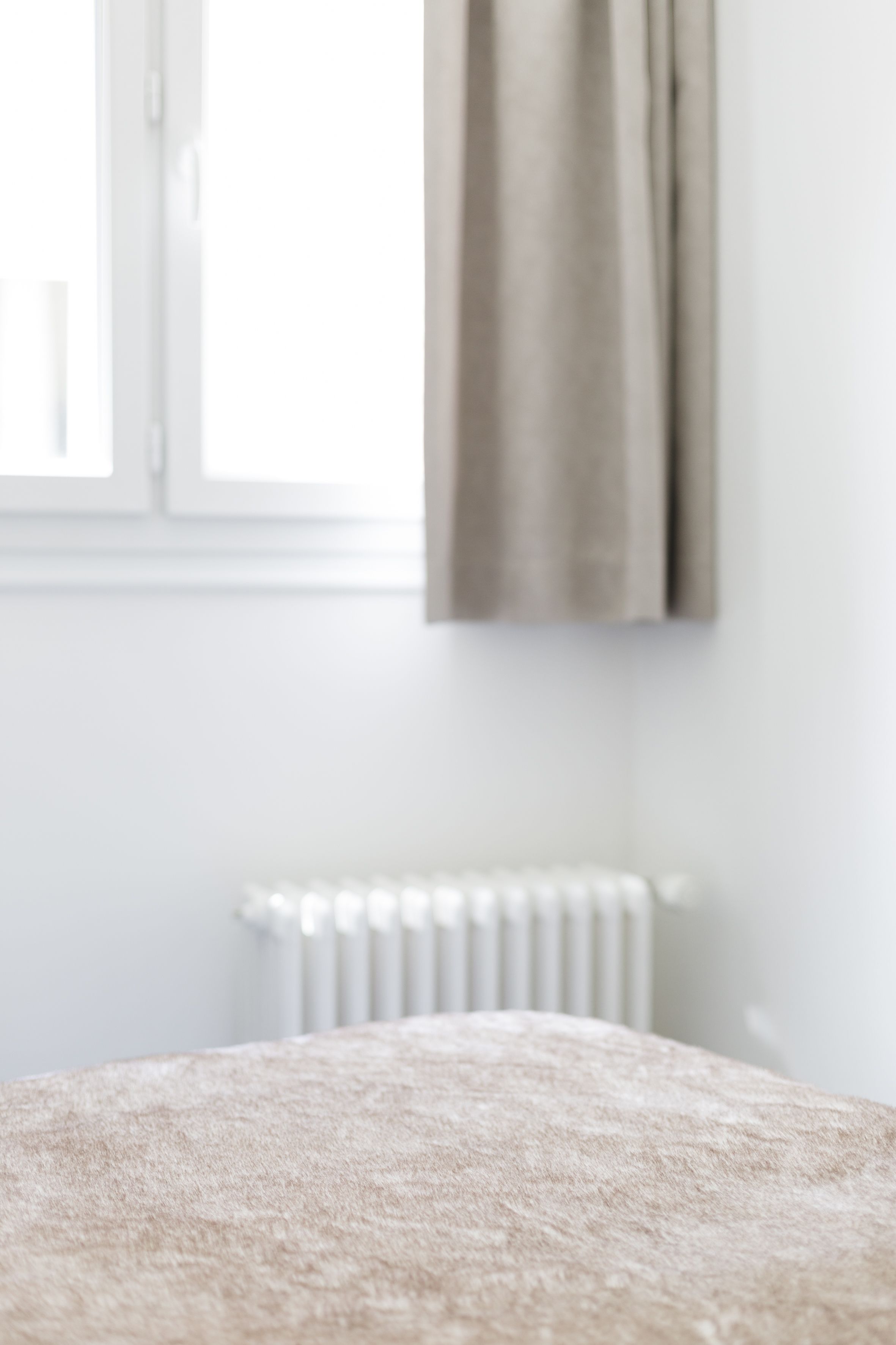 A room with a bed, a window, and a radiator.