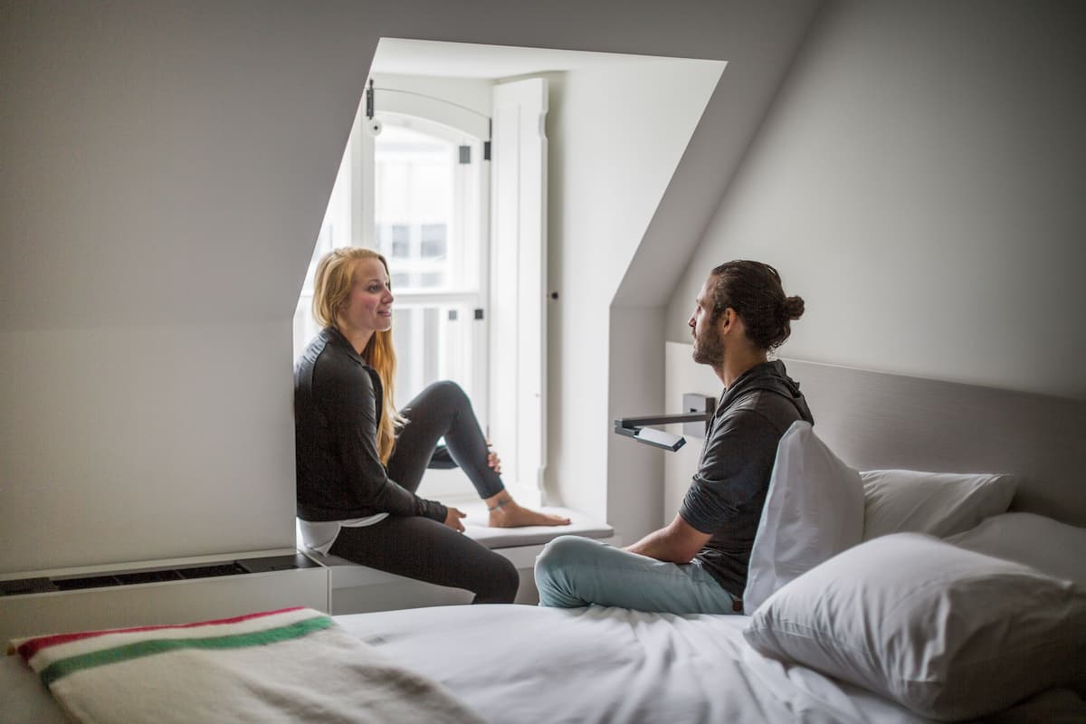 A room with a bed, a window, and a door.
