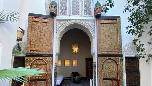 Una entrada ornamentada con labores de azulejos intrincados y un diseño de suelo a cuadros.