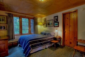 A bedroom with a bed, wooden wardrobe, and a desk. - Twin Top Lodge (Incline Village)