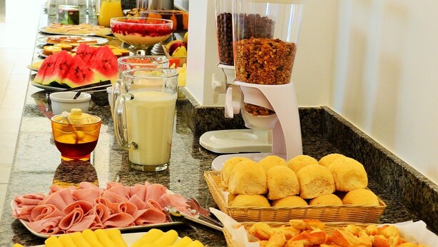 A buffet with various food items including fruits, meats, and condiments.