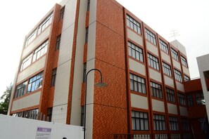 A multi-story building with a patterned facade, large windows, and a visible antenna on the roof. - Guaxuma Praia Hotel (Maceió)