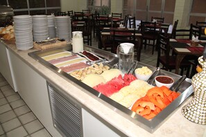 Um buffet com diversos pratos e acompanhamentos.