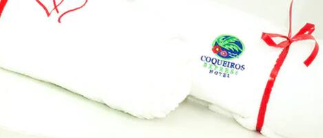 A white hotel pillow with a logo and text 'COQUEIROS PRESS HOTEL'.