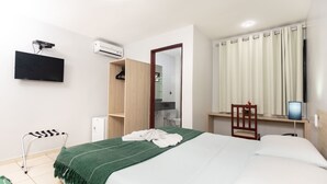 A hotel room with a bed, a TV, a desk, and a wardrobe. - Hotel Ciribaí (Maceió)