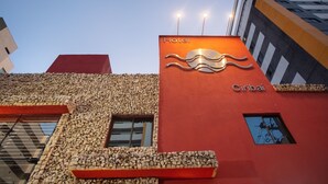 A hotel with a red facade, a wave design, and the name 'Ciribai' on the side. - Hotel Ciribaí (Maceió)