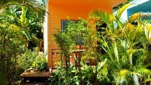 A modern yellow building surrounded by lush tropical vegetation. - Rewadee Garden Resort (Koh Samui)