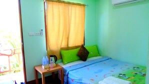 A small, brightly lit room with a bed, a nightstand, a window with curtains, and an air conditioning unit. - Rewadee Garden Resort (Koh Samui)