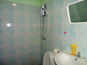 Un baño con inodoro, lavamanos y ducha.
