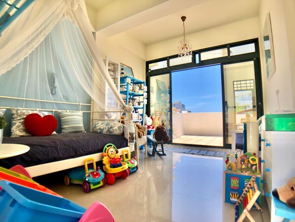 Un dormitorio con cama con dosel, un ventanal grande y un balcón con juguetes.