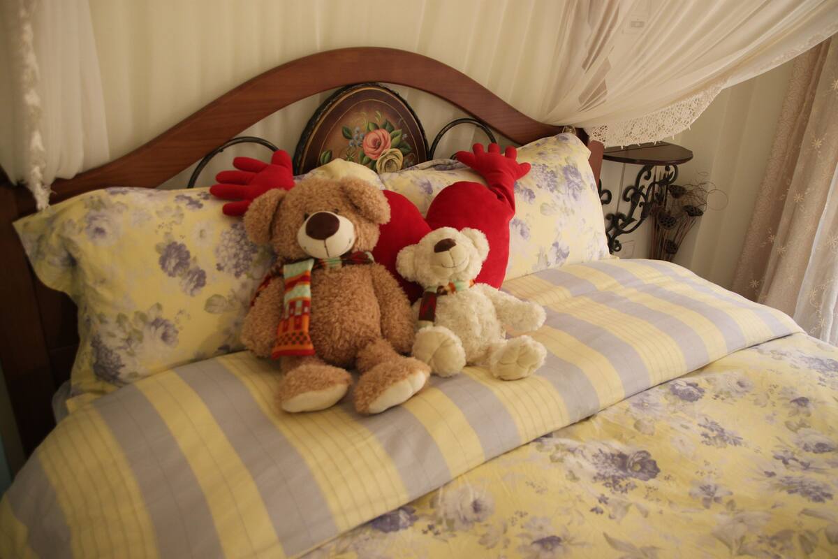 A bed with floral bedding and a wooden headboard.