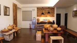 A modern kitchen with wooden furniture, a dining table, and a refrigerator. - Romeo B&B (Taitung)