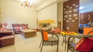 En stue med sofa, lænestole, sofabord og spisebord med stole.
